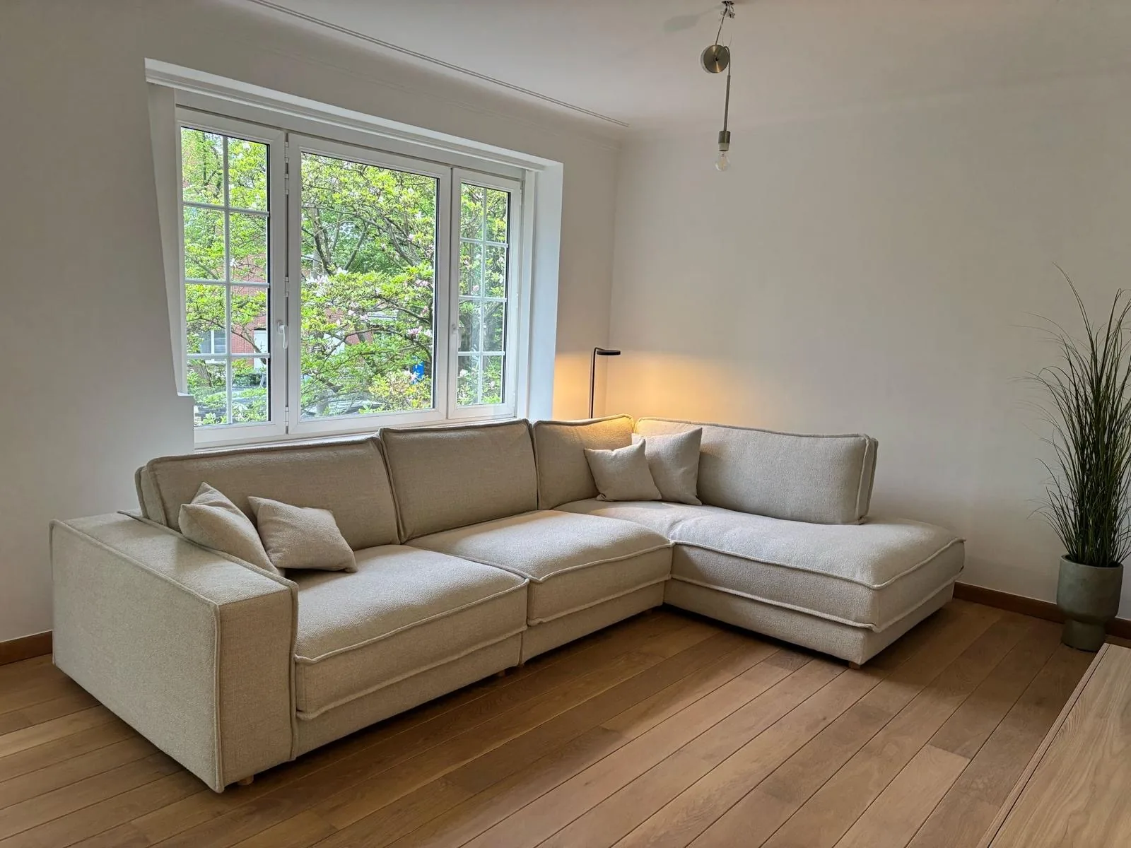 Woonkamer met lichte muren en een beige hoekzetel, project Pure Matter