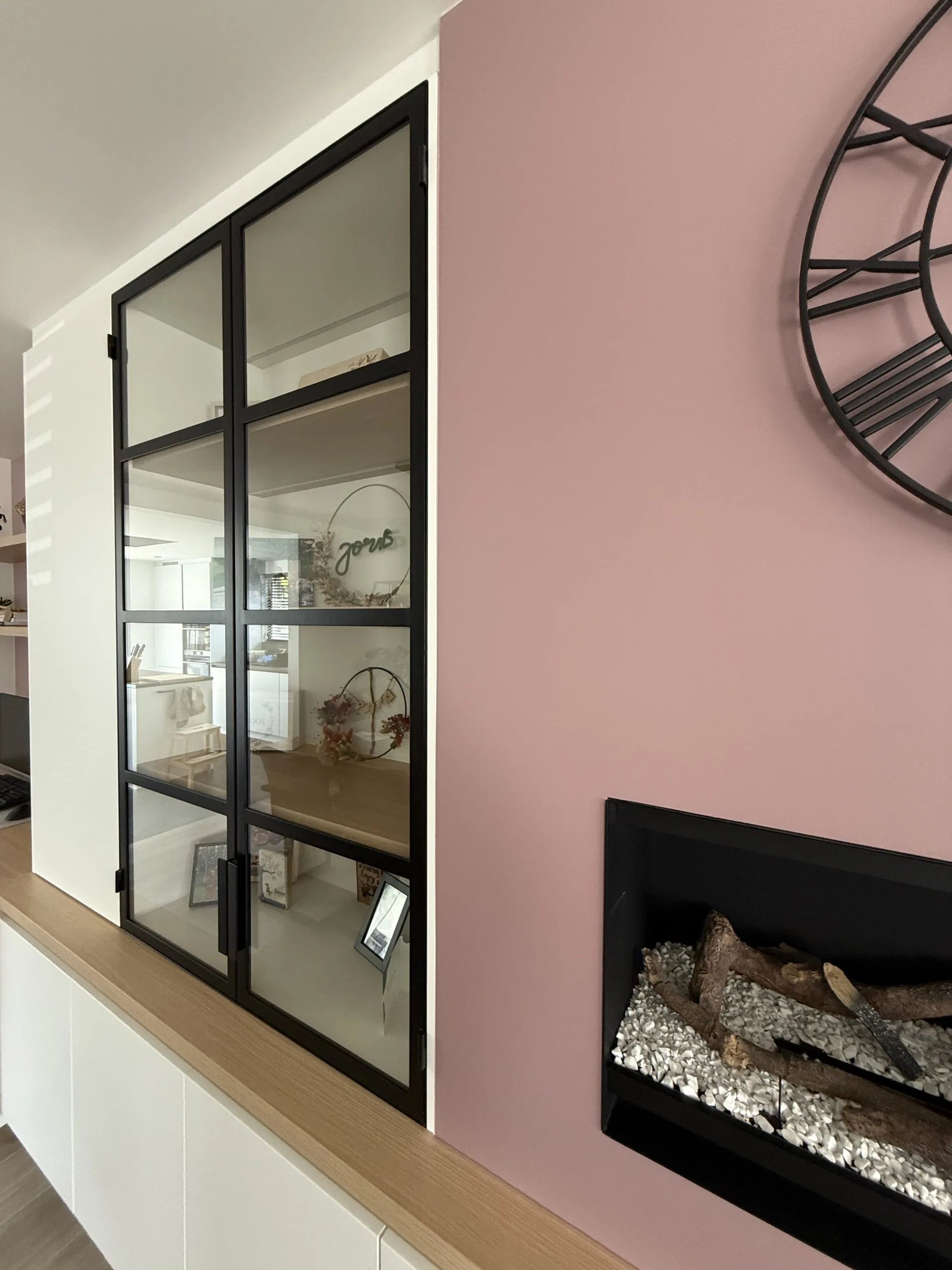 Haardwand in oudroze naast een zwarte glazen binnenwand, project Rosewood Harmony